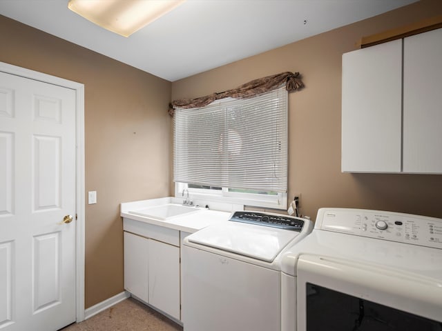 laundry room with sink, washer and clothes dryer, light colored carpet, and cabinets