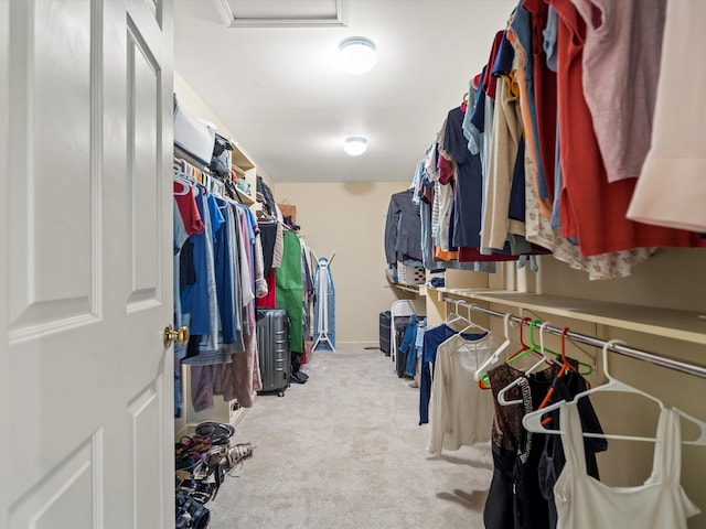 walk in closet featuring light colored carpet