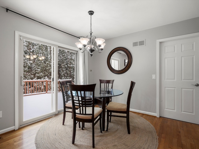 dining room with hardwood / wood-style flooring and a chandelier