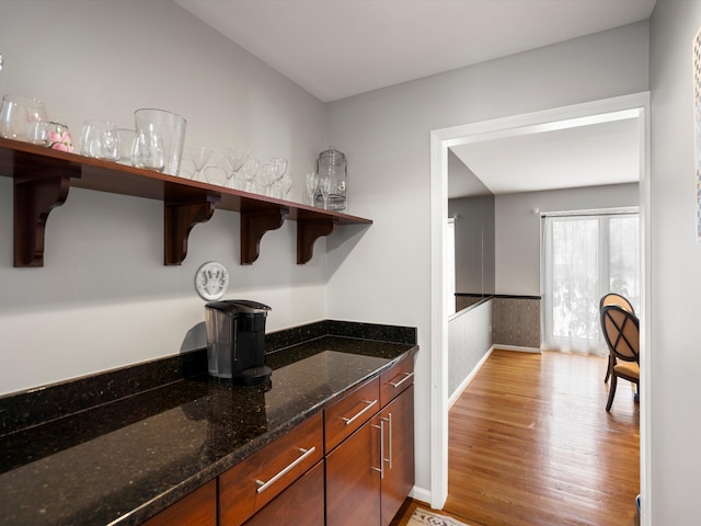 kitchen featuring light hardwood / wood-style flooring and dark stone countertops