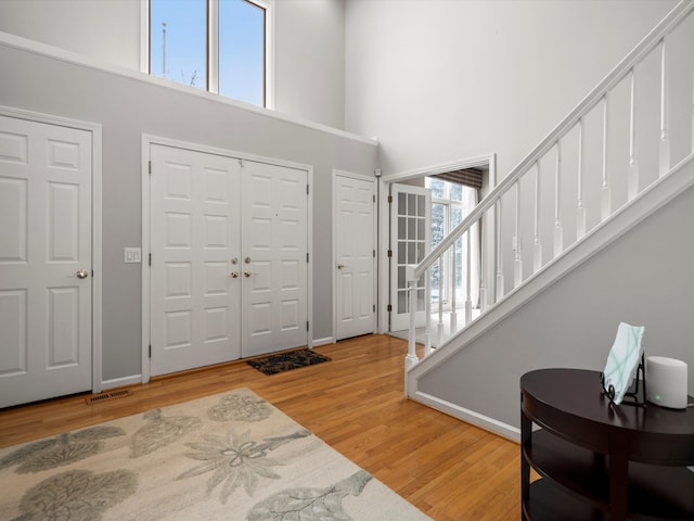 foyer entrance featuring hardwood / wood-style flooring and a high ceiling