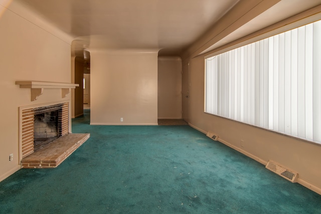 unfurnished living room with a fireplace and dark colored carpet