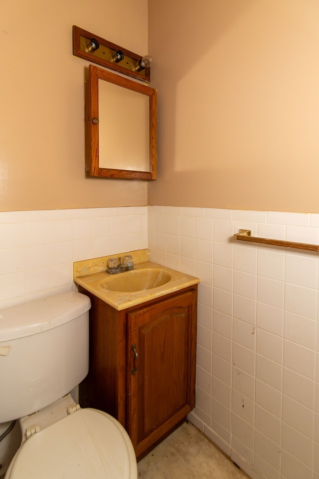 bathroom with tile walls, vanity, and toilet