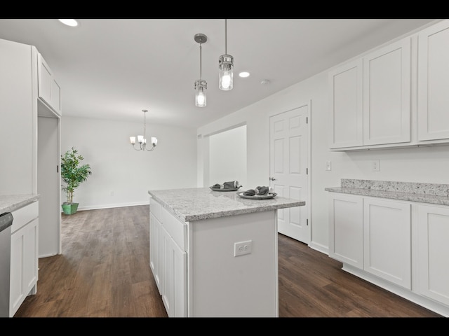 kitchen with hanging light fixtures, white cabinets, and light stone counters