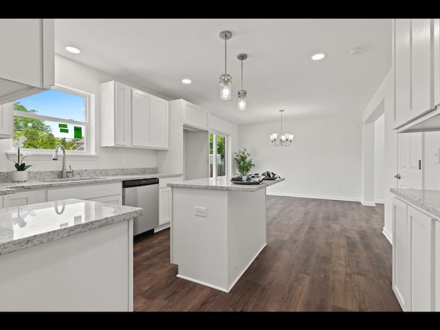 kitchen with white cabinetry, a kitchen island, stainless steel dishwasher, and light stone counters