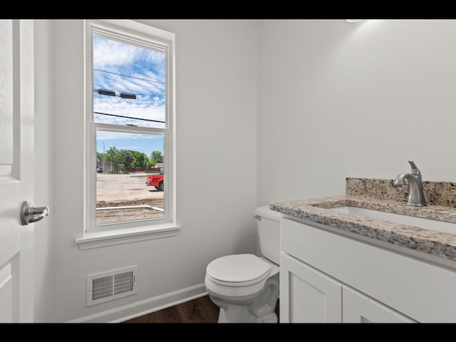 bathroom featuring hardwood / wood-style flooring, vanity, and toilet