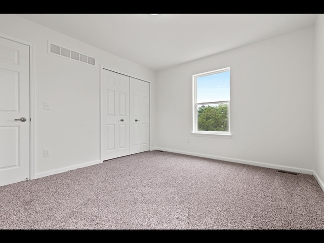 unfurnished bedroom with carpet floors and a closet