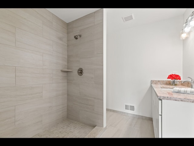 bathroom featuring vanity and a tile shower