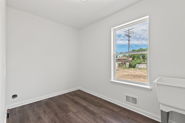 spare room with sink and dark wood-type flooring