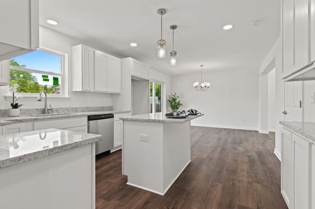 kitchen featuring sink, white cabinetry, stainless steel dishwasher, a kitchen island, and light stone countertops