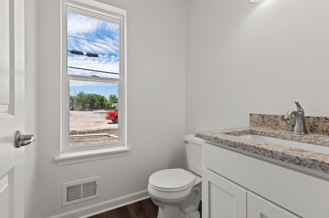 bathroom featuring vanity, hardwood / wood-style flooring, and toilet