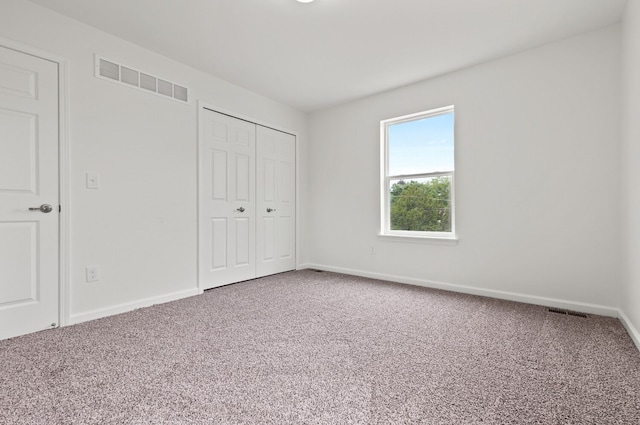 unfurnished bedroom with a closet and carpet flooring