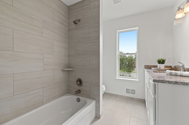 full bathroom with vanity, toilet, and tiled shower / bath combo