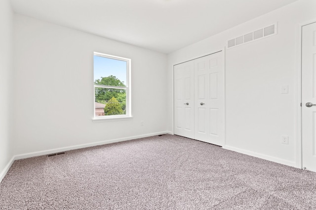 unfurnished bedroom featuring carpet floors and a closet