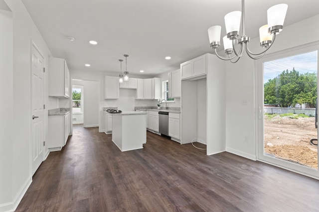 kitchen with a kitchen island, pendant lighting, white cabinets, stainless steel dishwasher, and light stone countertops