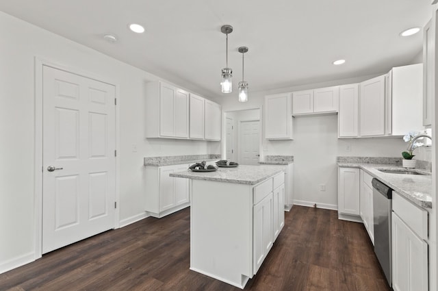 kitchen with pendant lighting, sink, a kitchen island, and white cabinets