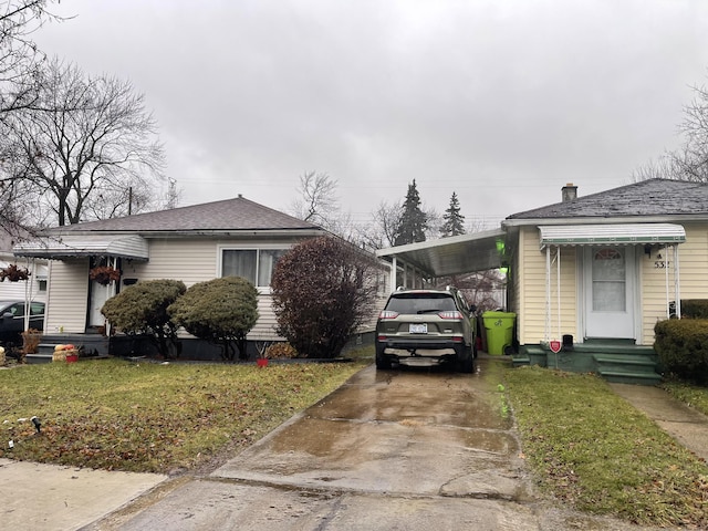 view of side of home featuring a carport and a lawn