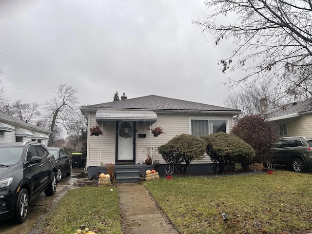 bungalow-style house featuring a front lawn