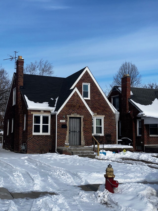 view of front of property with brick siding and a chimney