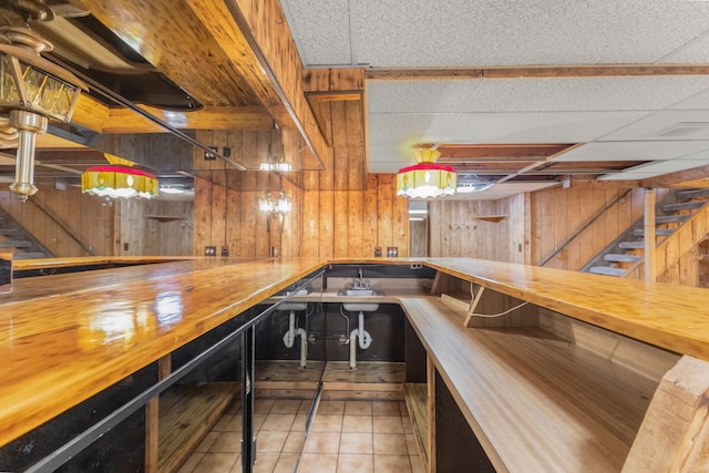 bar with light tile patterned flooring, wood counters, and wood walls