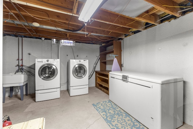 clothes washing area with independent washer and dryer and sink