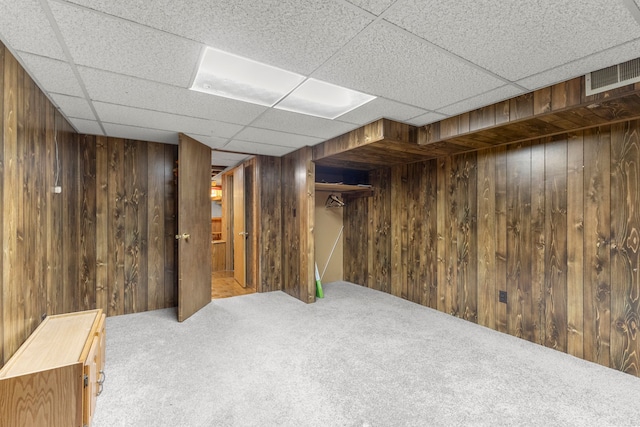 basement featuring carpet floors and wood walls