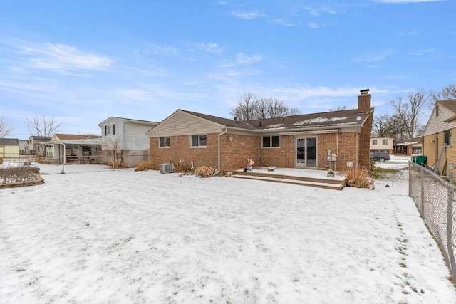 snow covered house with a wooden deck and central AC