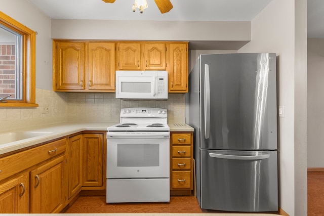 kitchen with tasteful backsplash, sink, white appliances, and ceiling fan