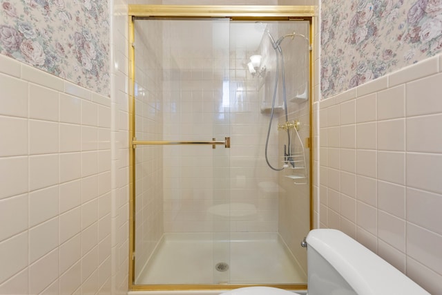 bathroom featuring tile walls, an enclosed shower, and toilet