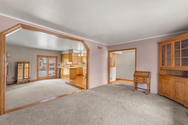 unfurnished living room with light carpet and ornamental molding