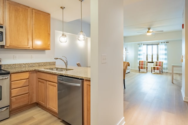 kitchen with sink, hanging light fixtures, light hardwood / wood-style floors, stainless steel appliances, and light stone countertops