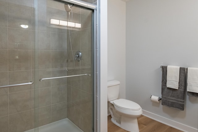 bathroom with hardwood / wood-style flooring, toilet, and walk in shower