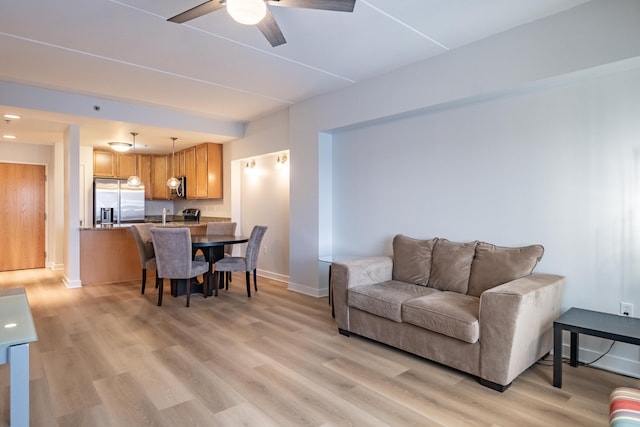 living room featuring ceiling fan and light hardwood / wood-style flooring