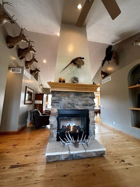 1084 38th St, Allegan, MI 49010 - living room featuring light hardwood / wood-style floors, a towering ceiling, a fireplace, and built in shelves