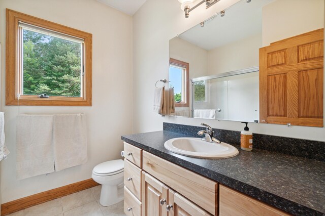 1084 38th St, Allegan, MI 49010 - bathroom featuring tile patterned flooring, vanity, a shower with door, and toilet