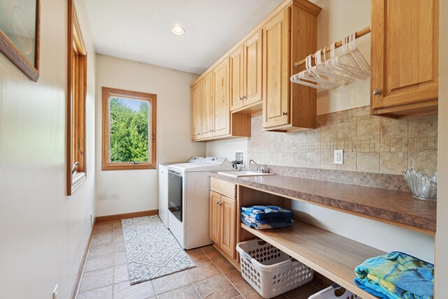 1084 38th St, Allegan, MI 49010 - laundry area with sink, light tile patterned floors, washer and clothes dryer, and cabinets