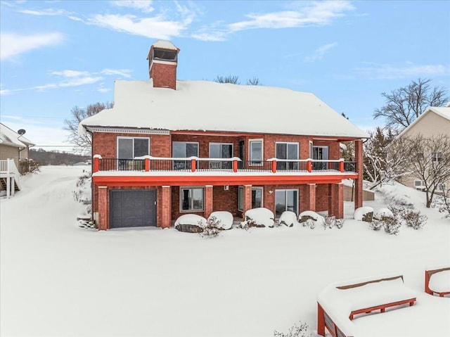 snow covered property with a garage