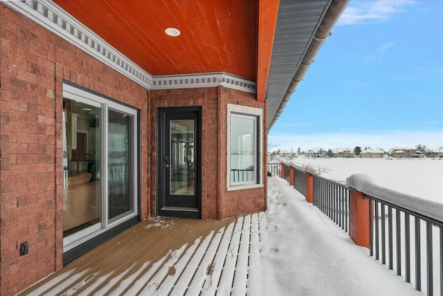 view of snow covered back of property