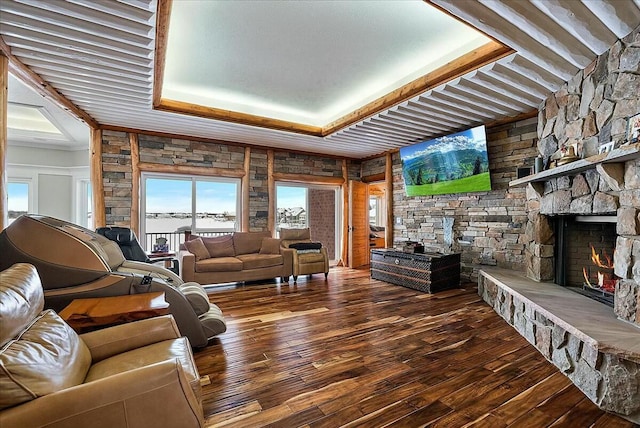 living room with hardwood / wood-style floors, a tray ceiling, and a fireplace