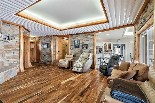 living room with a raised ceiling and wood-type flooring