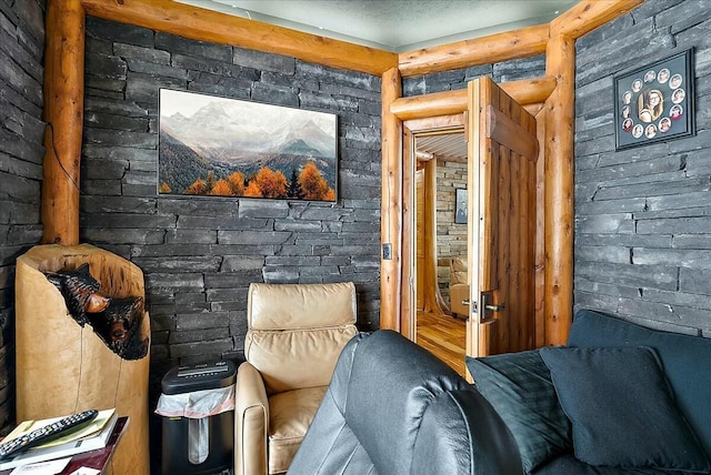 sitting room with rustic walls and a textured ceiling