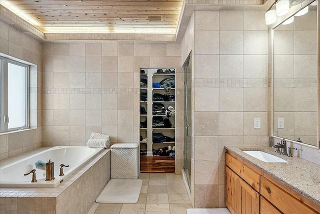 bathroom with wood ceiling, vanity, plus walk in shower, and tile walls