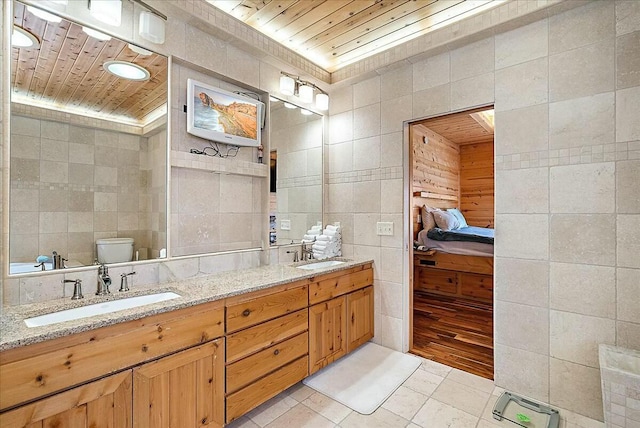 bathroom with toilet, tile walls, wooden ceiling, vanity, and tile patterned flooring