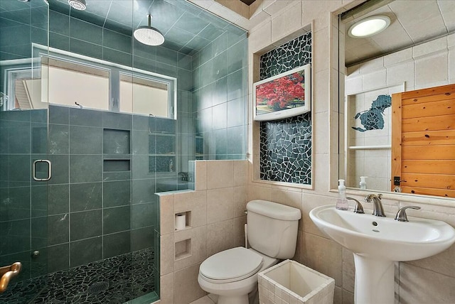 bathroom featuring tile walls, sink, toilet, and walk in shower