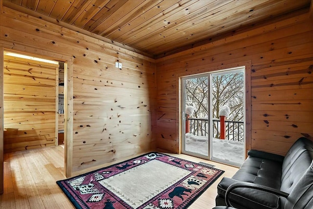 sitting room with wood ceiling, light hardwood / wood-style floors, and wood walls