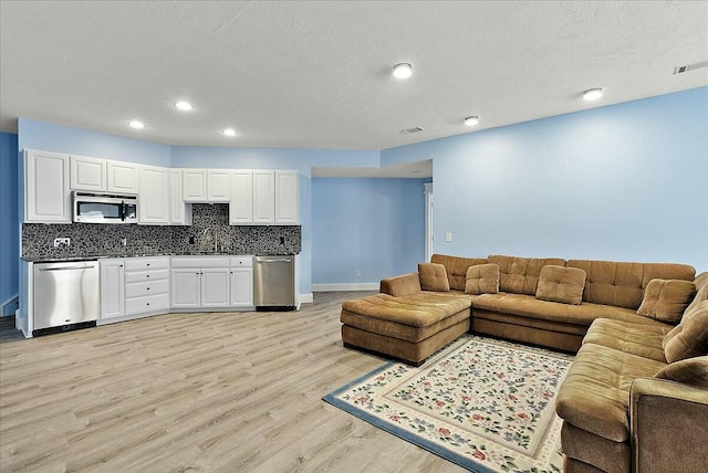 living room with sink and light hardwood / wood-style floors