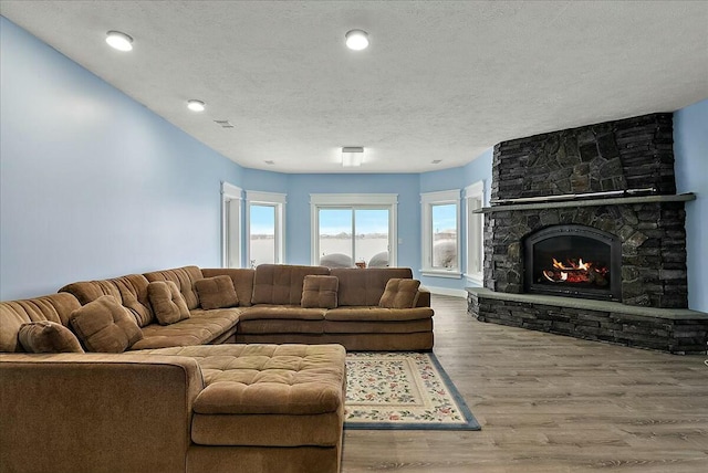 living room featuring hardwood / wood-style flooring, a fireplace, and a textured ceiling