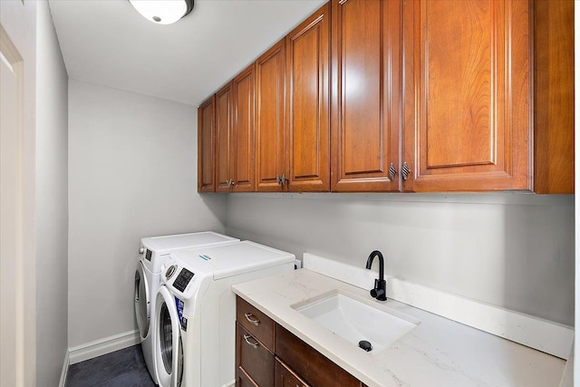 laundry area with independent washer and dryer, cabinets, and sink