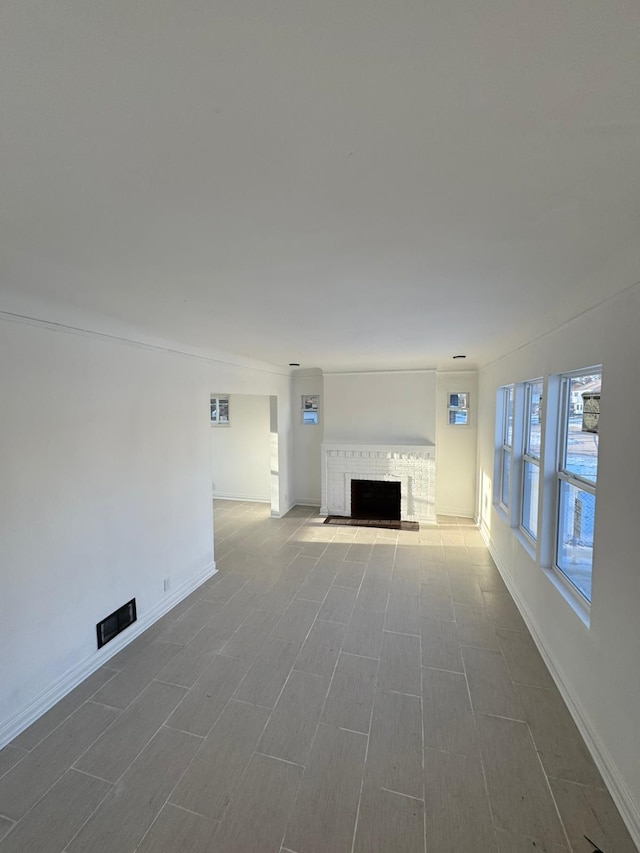 unfurnished living room featuring crown molding and a fireplace