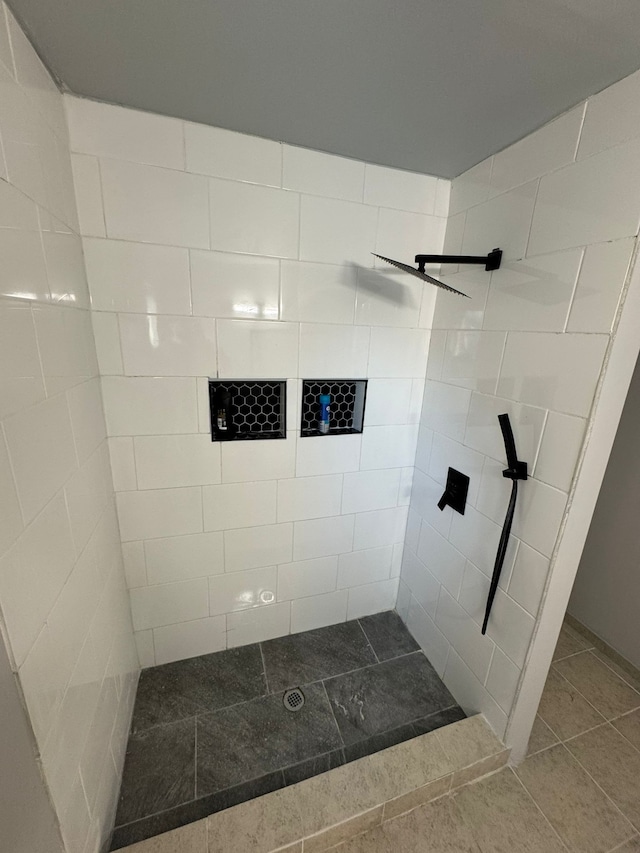 bathroom with tile patterned floors and tiled shower